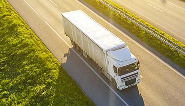 Industrial truck driving down highway.