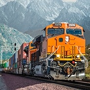 Train engine and raid cars on track through mountains.