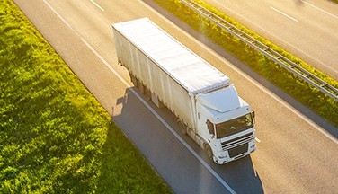 Industrial truck driving down highway.